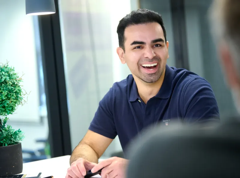 Ben Rahmani laughing during a conversation at a table in YourSpace Bournemouth