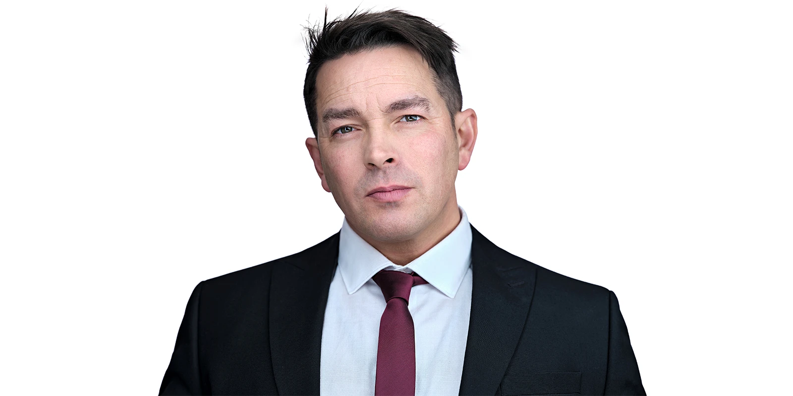 Three-quarter headshot of Davey Jones against a dark background, wearing a navy roll-neck