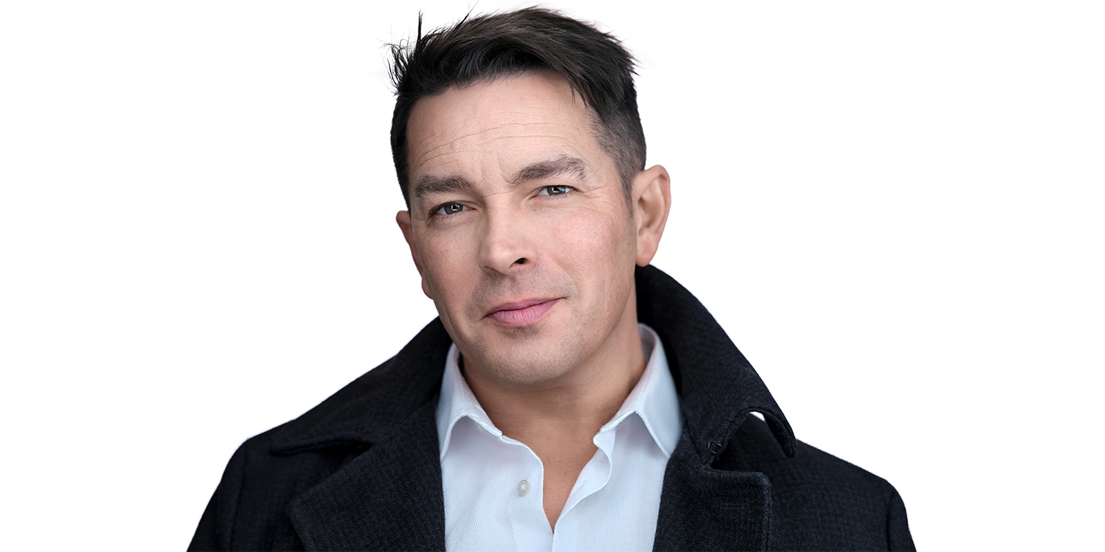 Davey Jones on a clean white background, wearing a dark coat and open-collar shirt