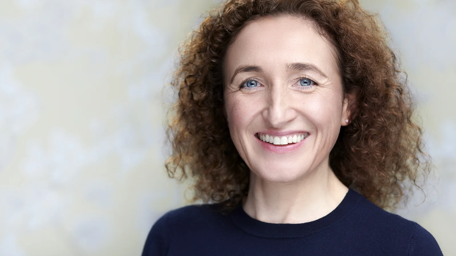 Lizzie Butler professional headshot, warm smile against a neutral background, ideal for LinkedIn and professional profiles