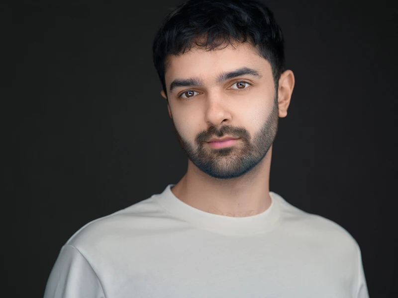 Professional portrait of a man in a light top on a dark background