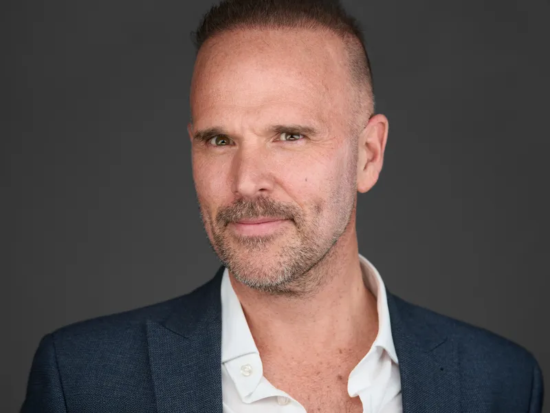Professional man with beard in navy textured blazer and white shirt, sophisticated executive portrait