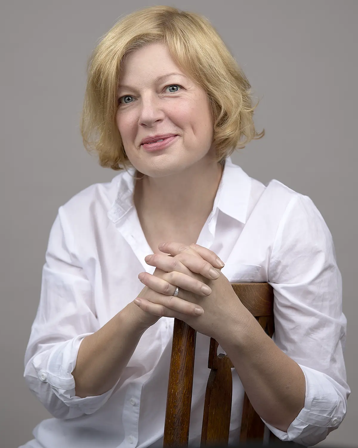 Professional business portrait in Exeter of a blonde woman seated on a chair