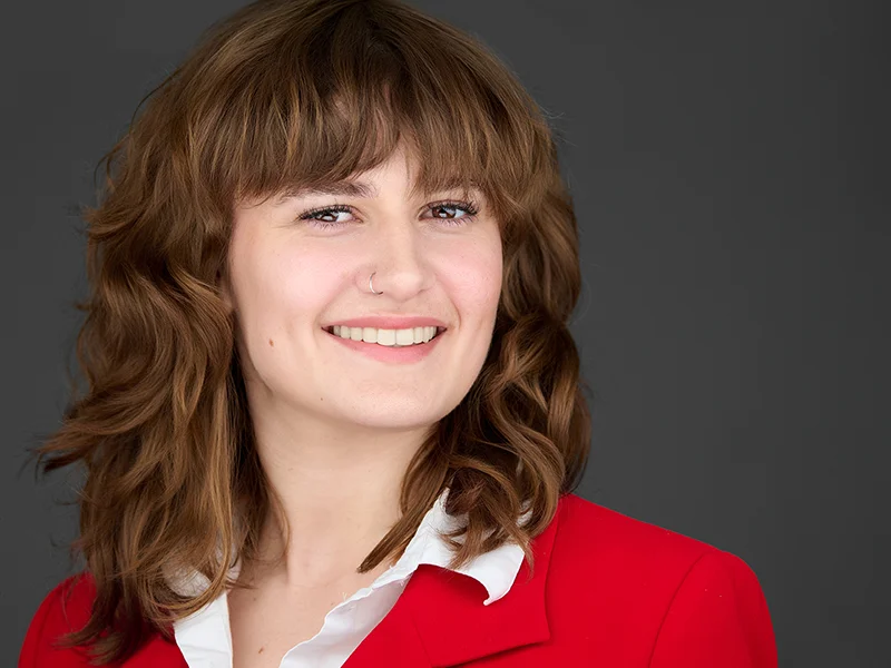 Exeter insurance executive in a red jacket smiling naturally - showcasing our portrait lighting style.