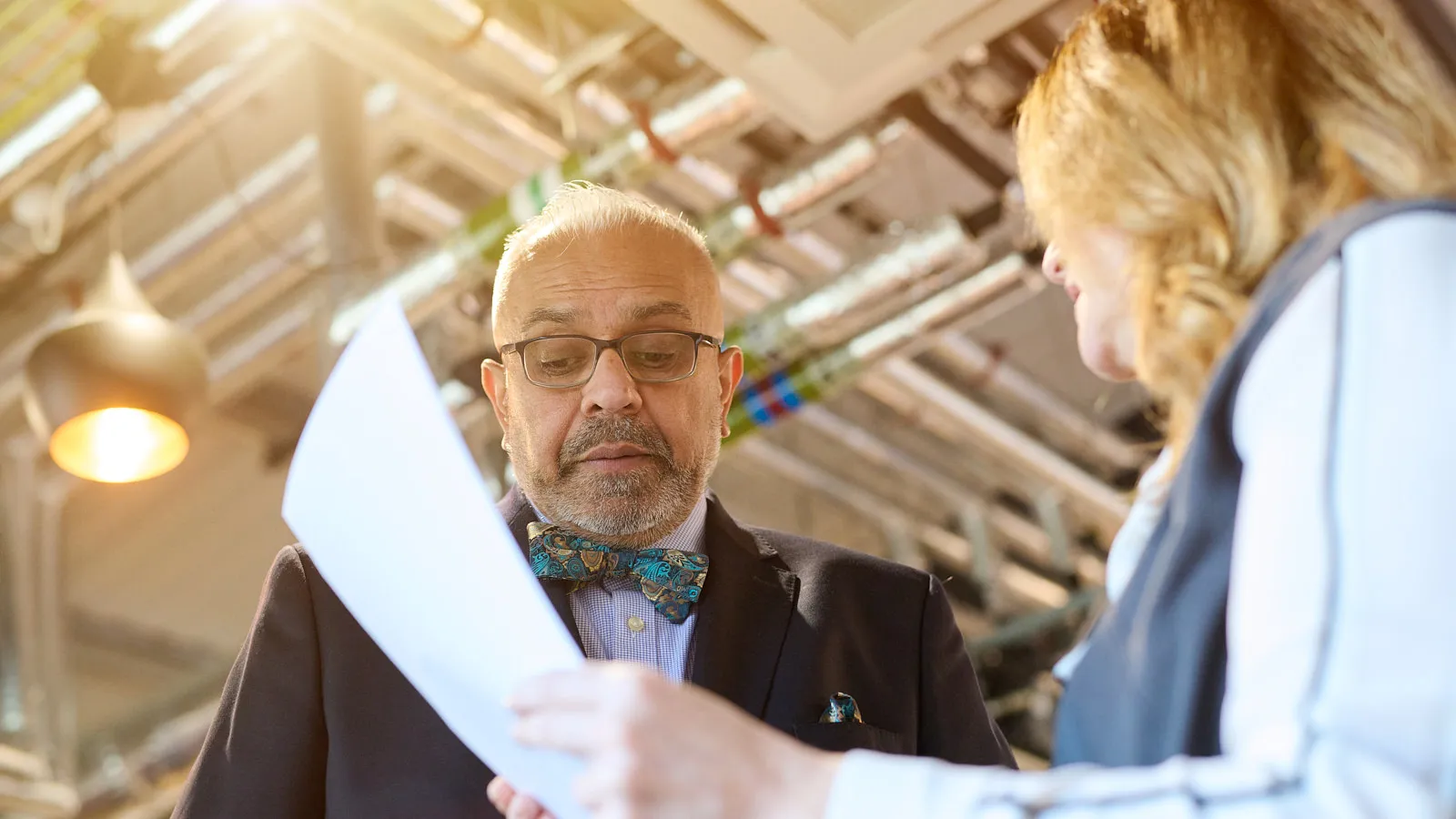 Christian reviewing notes and preparing to present in a formal boardroom setting