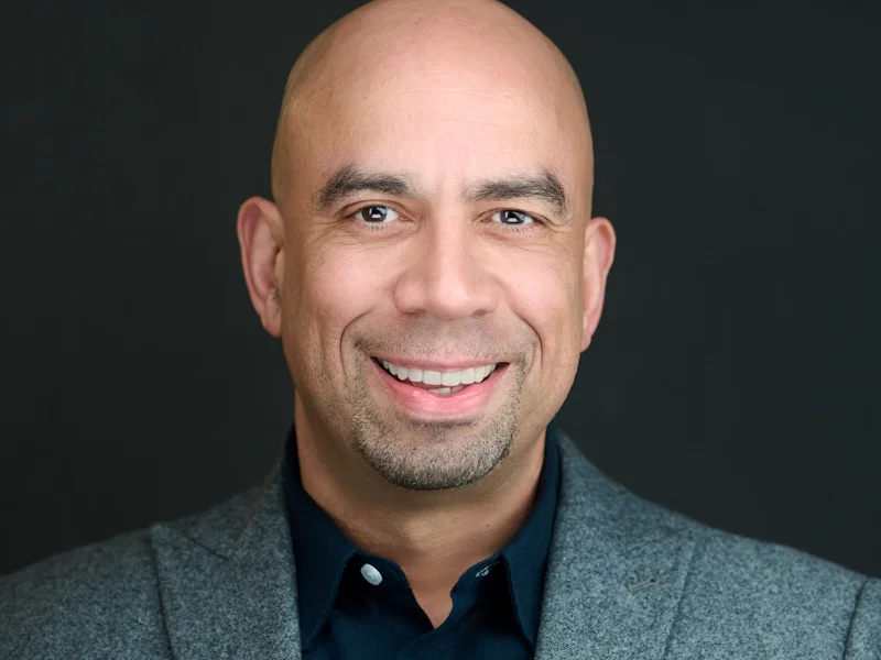 London executive commanding professional presence in his workplace headshot, his expression capturing confidence