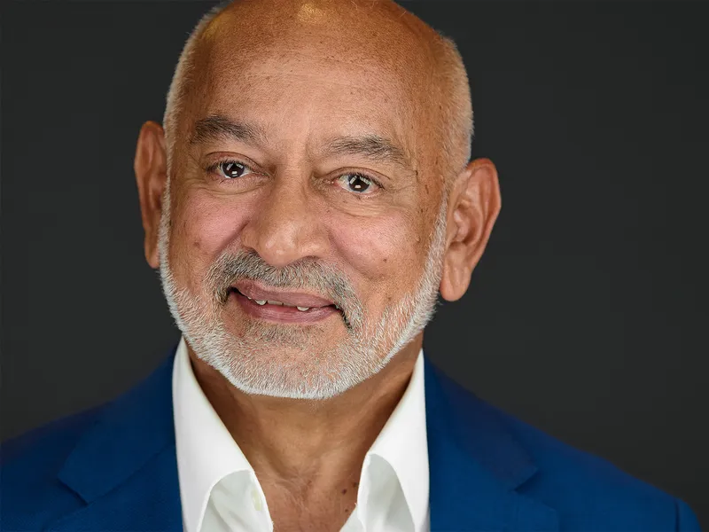 Distinguished senior executive with beard in blue blazer and white shirt, confident professional portrait