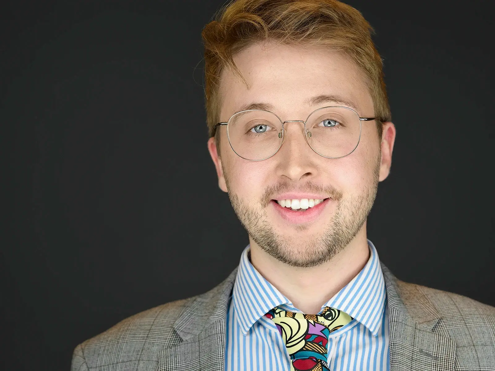 Man in checked blazer and artistic tie demonstrating how professional headshots can reflect personal style