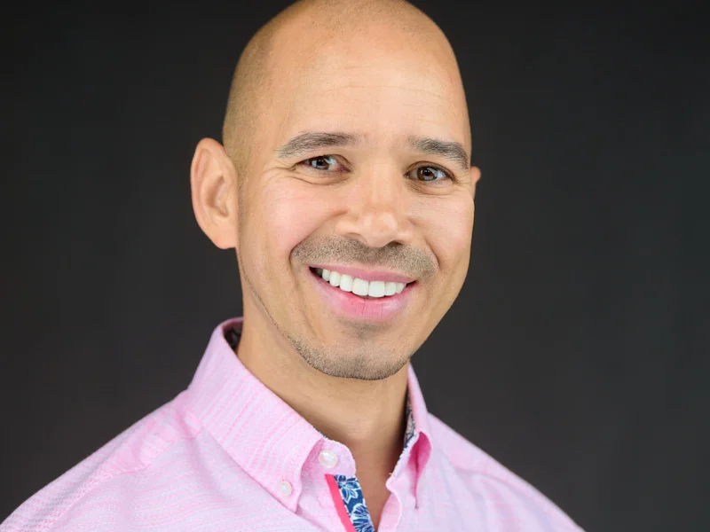 Advisor in pink shirt with distinctive collar detail sharing an approachable, trustworthy smile.