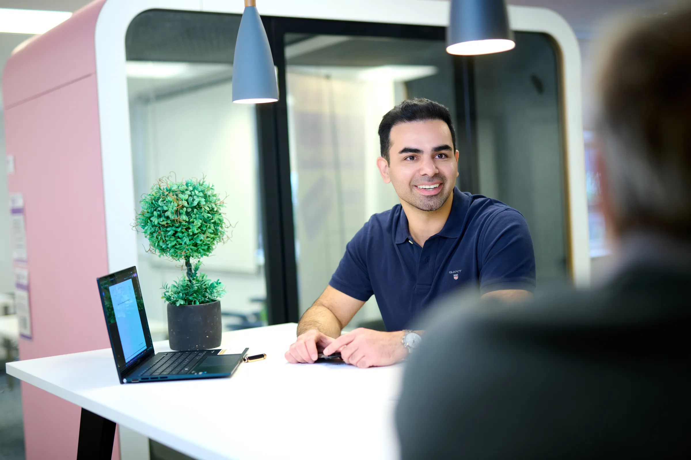 Ben Rahmani smiling while seated at a meeting table in YourSpace Bournemouth