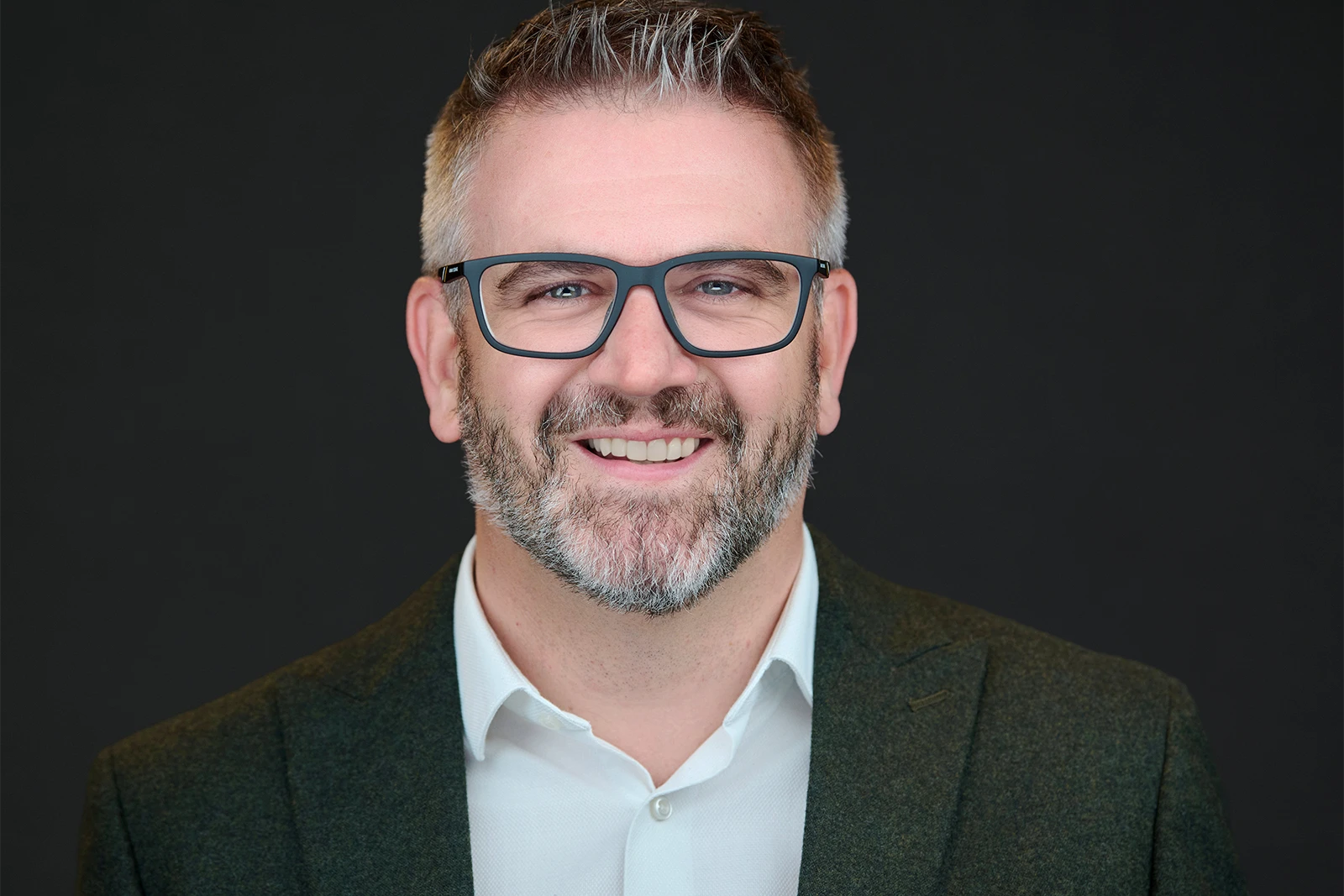 Professional wearing classic acetate frames during a headshot session with clean, reflection-free lenses