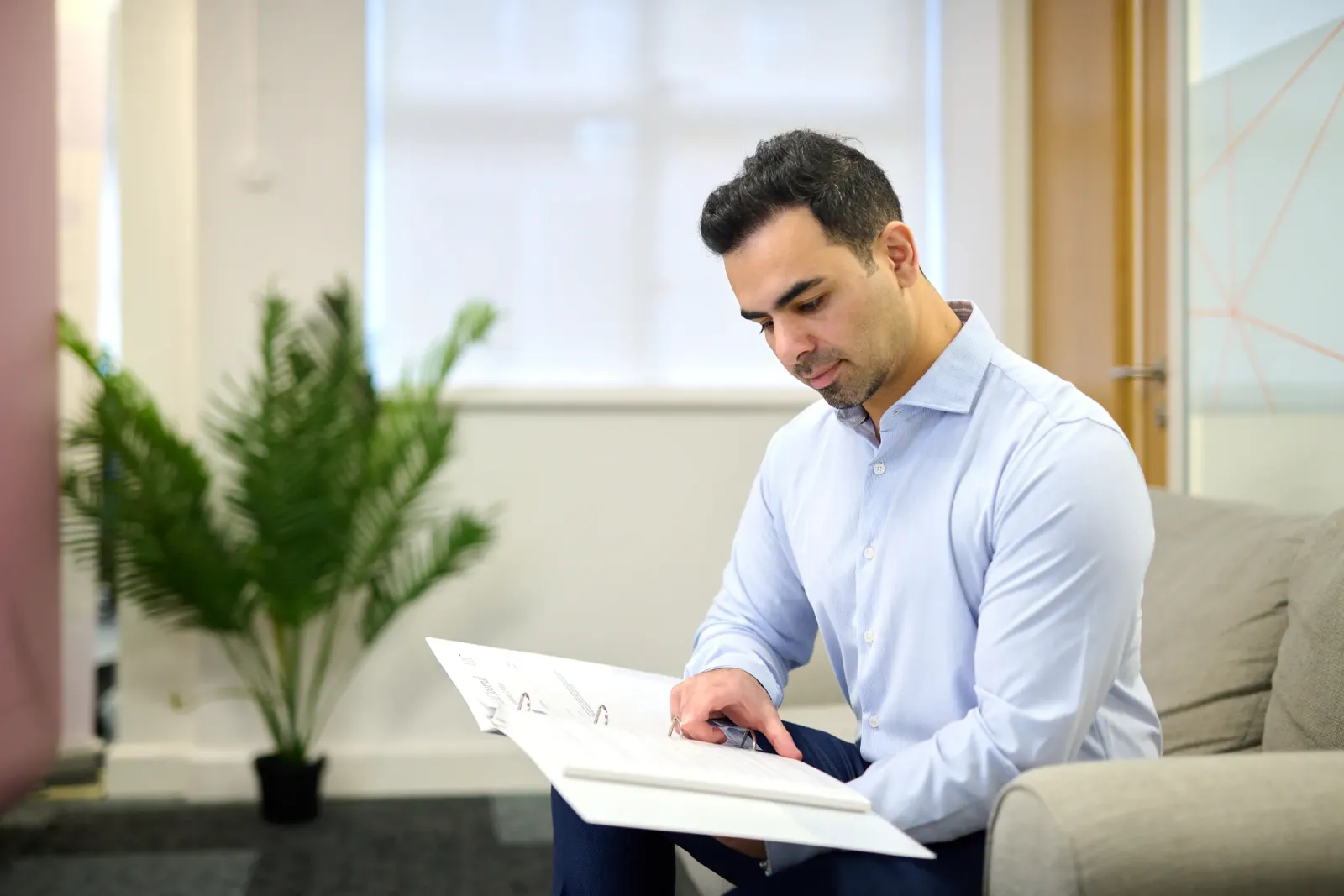 Personal branding for a MedTech founder: reviewing documents on a sofa in a modern office