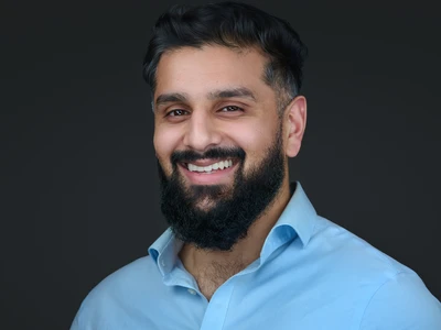 Bearded man in a dark grey open-collar shirt, approachable and warm expression — Plymouth headshot