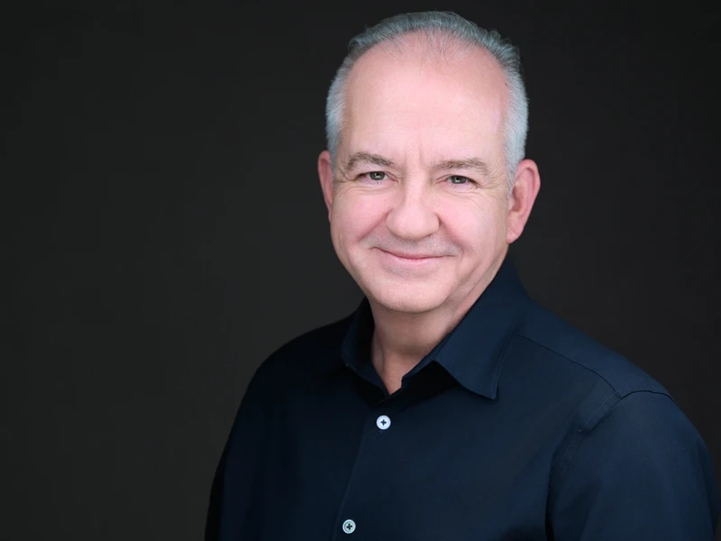 Man in a neat dress shirt, professional headshot with an easy natural look